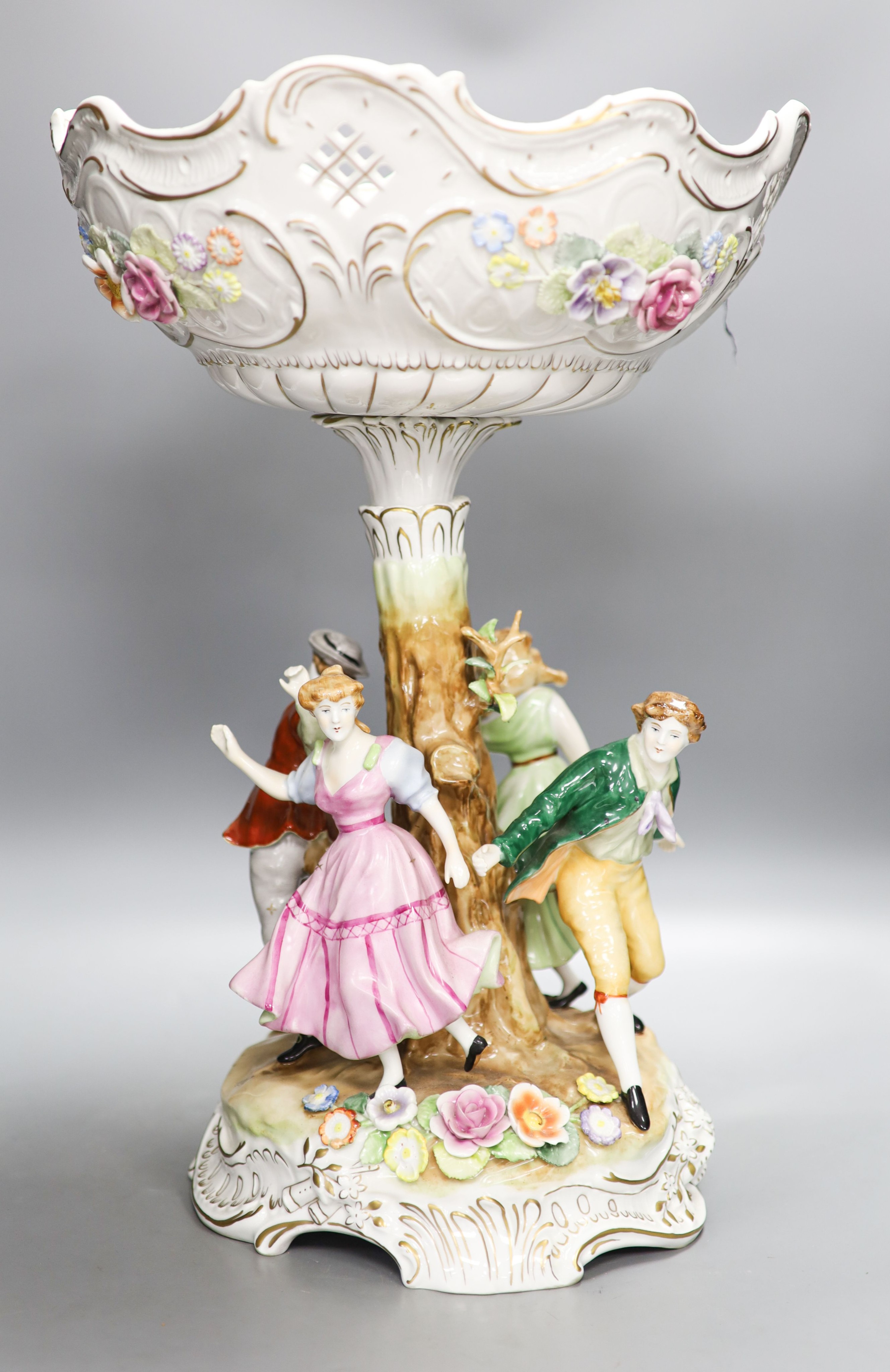 A German porcelain fruit stand, the stem decorated with four dancing figures 51cm